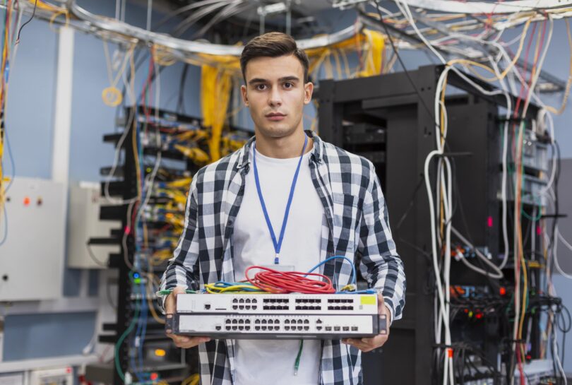 young man holding ethernet switches min